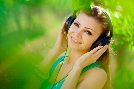 美女戴着耳机在户外听音乐
