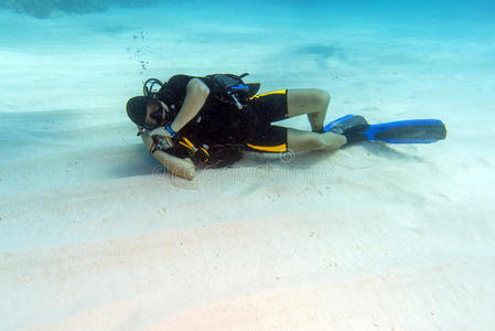 沉睡在沙质海底的潜水员照片