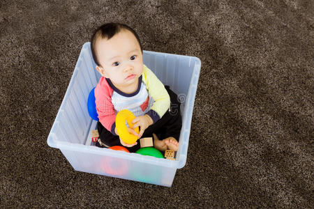 在塑料盒里玩耍的亚洲男婴