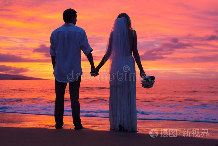 上的新婚夫妇新婚夫妇在热带海滩接吻刚结婚的一对手牵手婚礼刚结婚