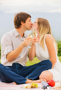 迷人的情侣在浪漫的午后野餐亲吻