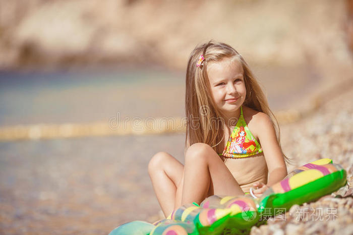 坐在海边海滩上的小女孩