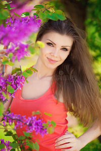 在温暖的夏日，美丽的年轻黑发女人在草地上开着白花