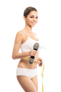 一个穿着运动服的年轻女子测量她的腹部