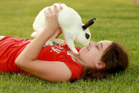 孩子和她的宠物兔子在户外玩耍