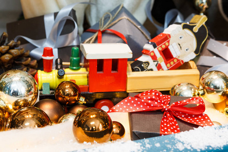 木制玩具火车作为圣诞礼物与闪亮的小玩意，假日背景