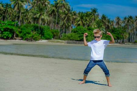 可爱的男孩在热带海滩上玩耍。白色 t 恤 大
