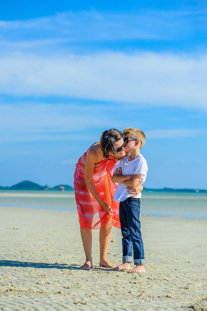亲吻妈妈.幸福的家庭妈妈和儿子热带海滩