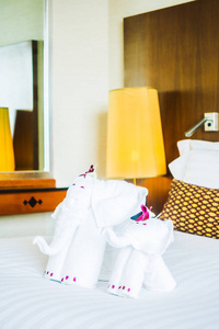 白色的大象毛巾装饰在酒店房室内床上