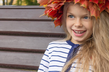 一个孩子在一个秋天花环的肖像