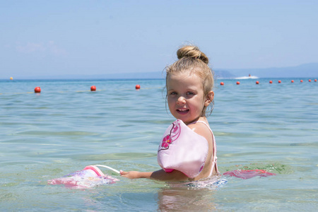 蓝色的水海中游泳的小女孩照片