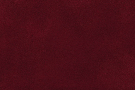 暗红色麂皮绒织物特写的背景.天鹅绒亚光质地的酒磨砂纺织照片