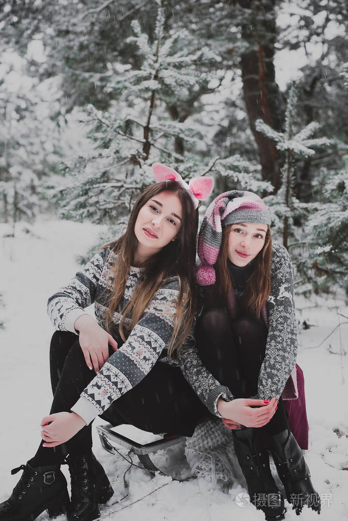 两个年轻的少女时髦女孩朋友在一起关闭了的两个姐妹拥抱时尚肖像和