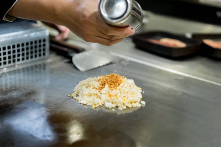 手的厨师烹饪大蒜炒米饭热平底锅在铜上
