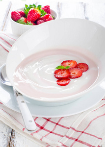 在一个碗里有新鲜的浆果的新鲜草莓酸奶
