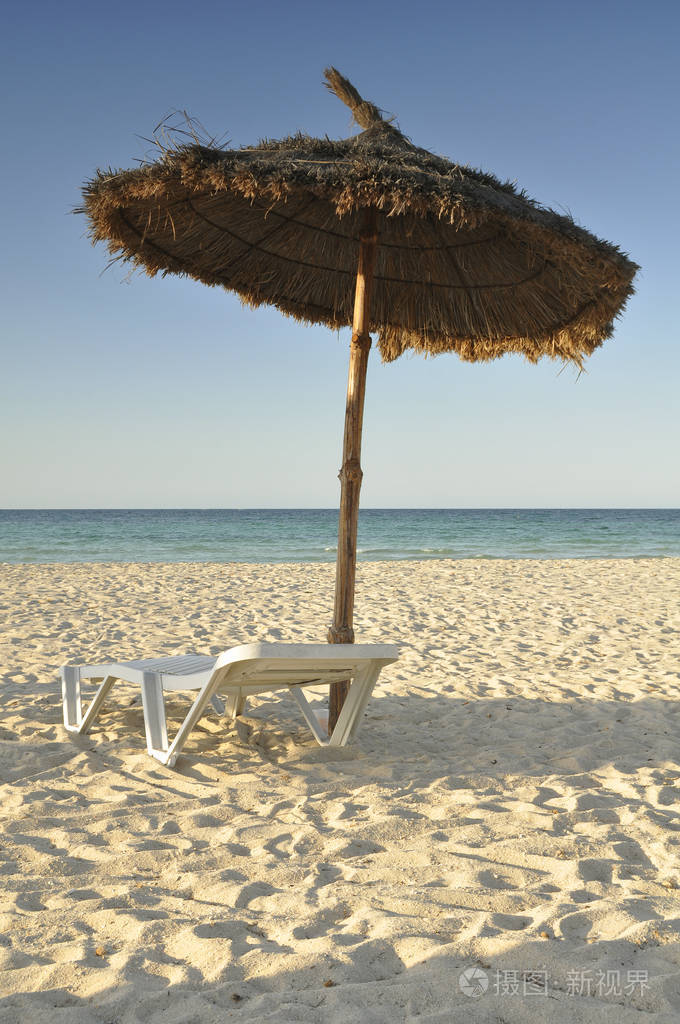 晚上在突尼斯海滩上的孤独海滩伞