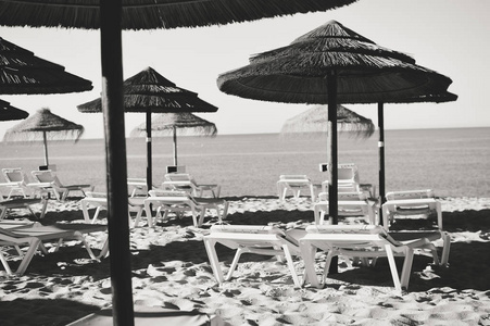 阳光明媚的天空和椅子与阳伞在美丽的葡萄牙海滩