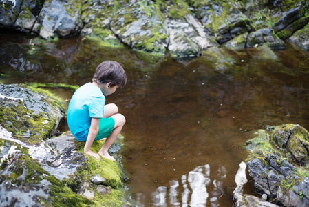 森林的小河边这个男孩在小河边照片