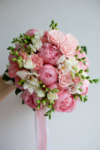 新娘的花束软粉红牡丹和白玫瑰。婚礼花艺。经典的窗体