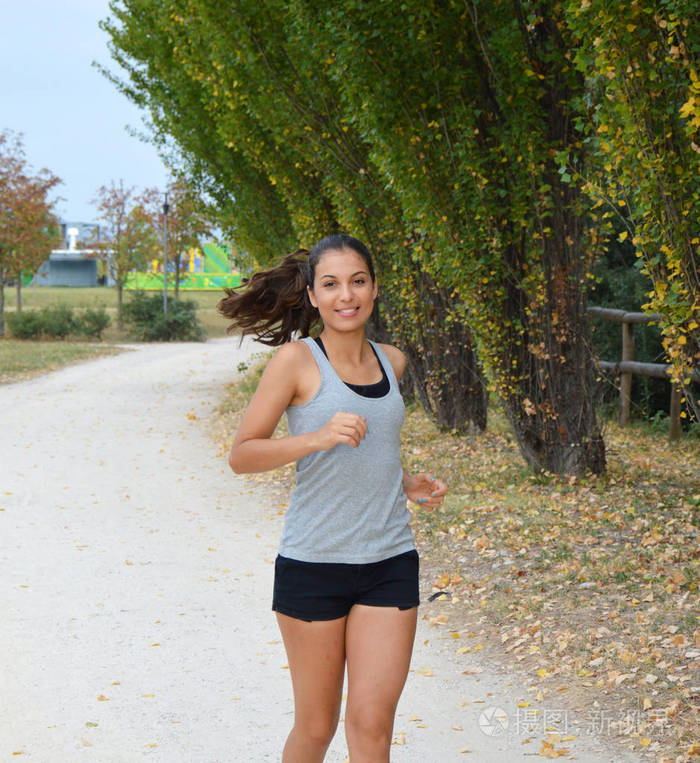 在公园跑步的小女孩微笑着.美丽的年轻健身女人户外跑步