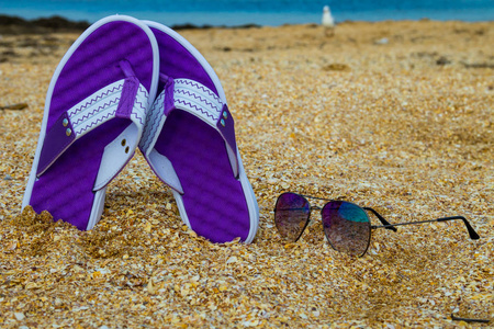 沙滩沙滩上的一双拖鞋和太阳镜