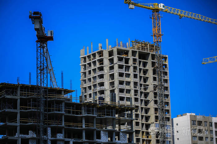 新的城市.机械, 起重机和建筑商在脚手架上.重工业和工作安全