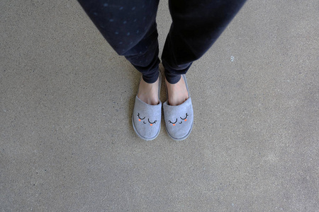 灰色拖鞋, 关闭女人的脚穿微笑灰色拖鞋在水泥背景