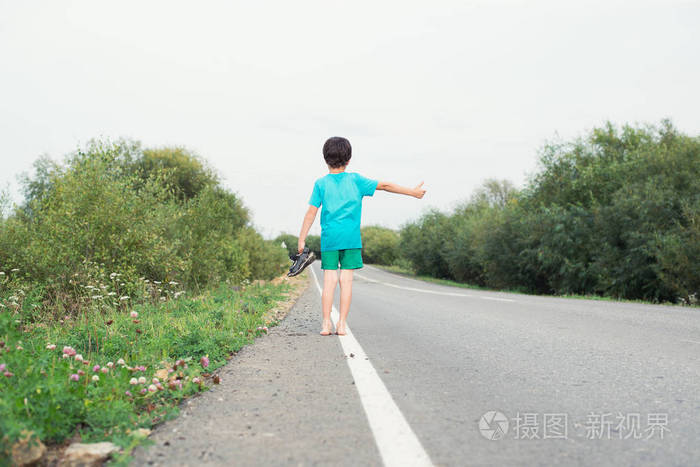 那个男孩沿着马路赤脚走