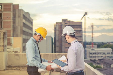 微笑年轻建筑师或工程安全帽与生成器