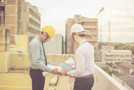 微笑年轻建筑师或工程安全帽与生成器