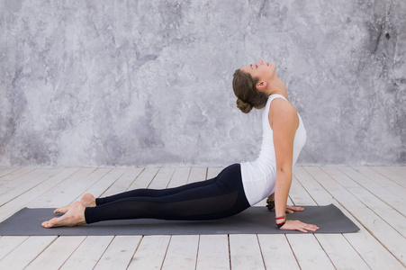 年轻漂亮的女性练瑜伽,站在山运动,山式的姿势,双手