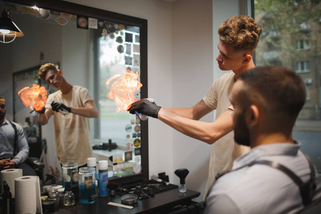 令人目眩的火焰令人愉快的理发师,喷火火焰用发胶和理发店背景上的