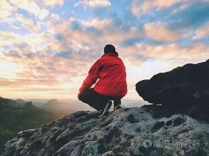 单身男人旅游坐在岩石帝国.观点与暴露岩石峰山谷上空