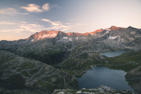 高海拔高山湖 水坝和水盆地在田园土地与雄伟的洛基山山峰在日落时发光。在阿尔卑斯山的广角视图