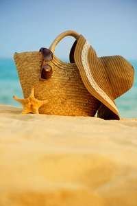 包的帽子和眼镜在海滩上
