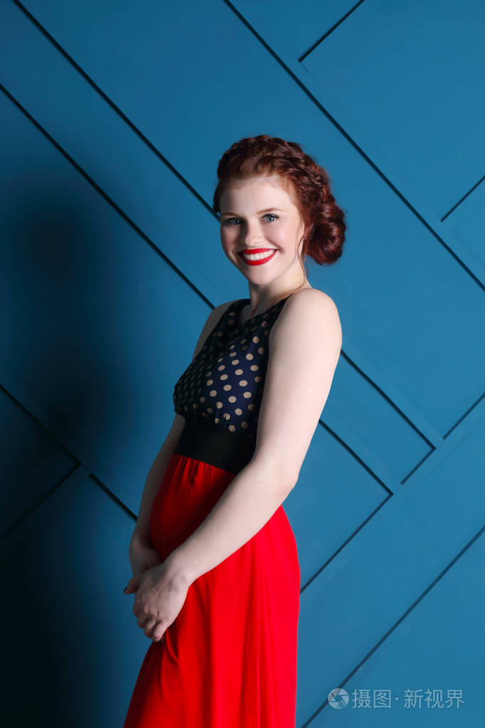 美丽的女人在b中长连衣裙笑容的化妆与发型