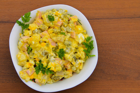 俄罗斯传统沙拉奥利维耶 · 木制的桌子上照片