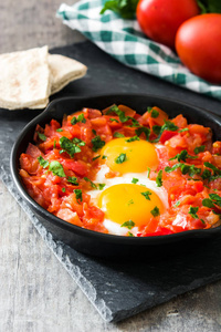 Shakshuka 在铁煎锅木制的桌子上。在以色列的典型食品