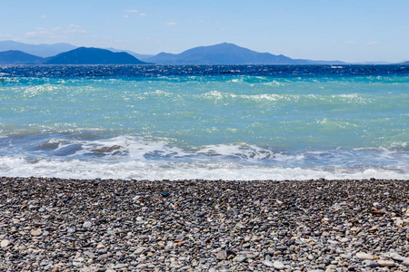 海浪花泡沫对海滩上的鹅卵石，海岸