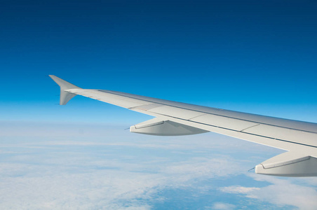 云层上方的飞机一架飞机在云层上方天空的翅膀照片