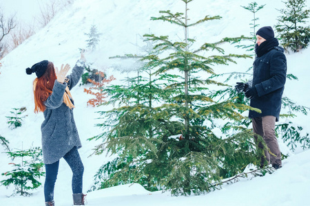 微笑对夫妇一起在白雪皑皑的树林里散步