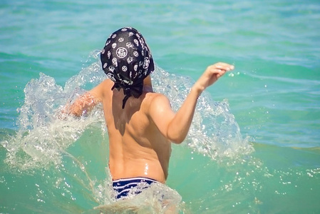 年轻的白人男孩跳在水里，地中海