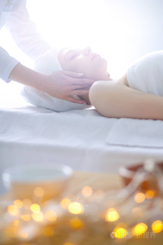年轻女子躺在按摩床上,闭着眼睛放松.女人.spa 沙龙