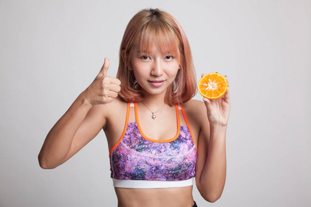 亚洲健康美女竖起大拇指用橙色水果