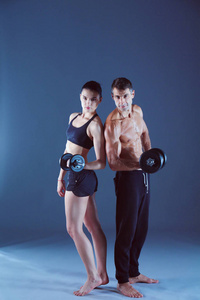 健壮的男人和女人的哑铃。私人健身教练。个人培训