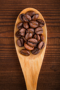 咖啡豆和肉桂放在一个背景下。烤咖啡豆背景特写..咖啡豆从顶部堆起，有文本的复制空间。调味料。香料。肉桂。巴迪安。咖啡屋。
