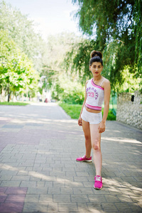 运动的女孩穿上白色短裤 ans 衬衫在公园锻炼