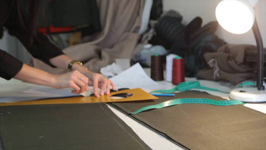Tailor.Hands 缺口裁缝裁缝剪刀布。女裁缝缝合材料的工作场所。准备制作衣服的面料。缝纫 制衣业 设计师讲习班的概念