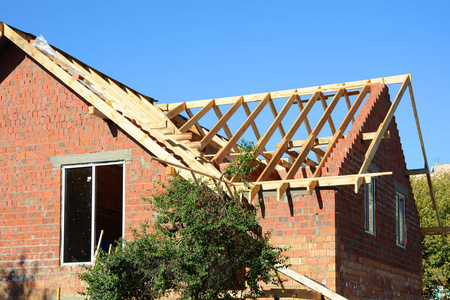 未完成的房屋建筑.安装的木梁施工在房子的屋顶桁架系统照片