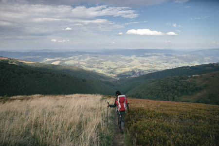 徒步旅行女人在山上，鼓舞人心的景观。动机的徒步旅行者背包看山景